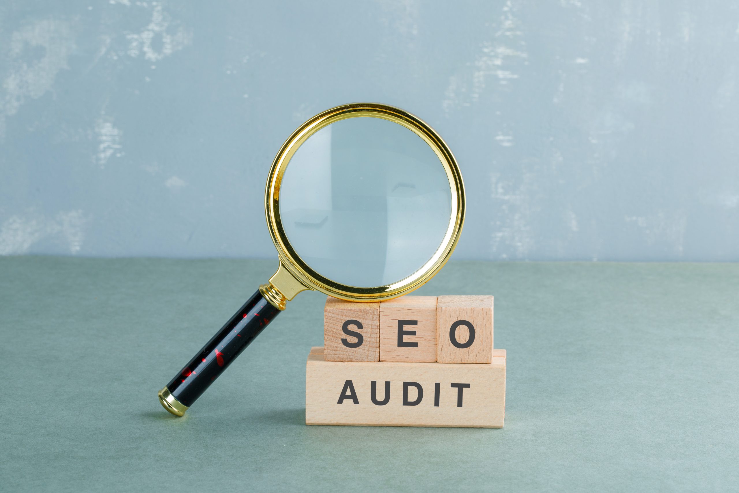 Seo analysis and business concept with wooden blocks with words on it, magnifying glass on sage color background side view. horizontal image Seo analysis and business concept with wooden blocks with words on it, magnifying glass on sage color background side view. horizontal image